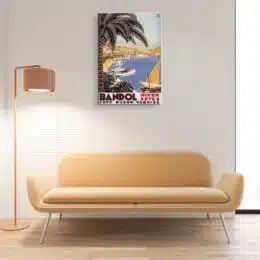 Tableau vintage bandol accroché sur un mur avec un canapé et veilleuse dans un salon
