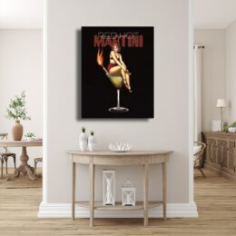 Tableau MARTINI écrit en rouge sur fond noir, une femme en maillot rouge dans un verre à cocktail et une allumette enflammée au-dessus d'une console en bois patinée avec 2 vases posés dessus et des lampes en dessous