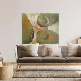 Tableau kaki peinture abstraite au dessus d'un canapé moderne aux tons beiges et marrons clair.