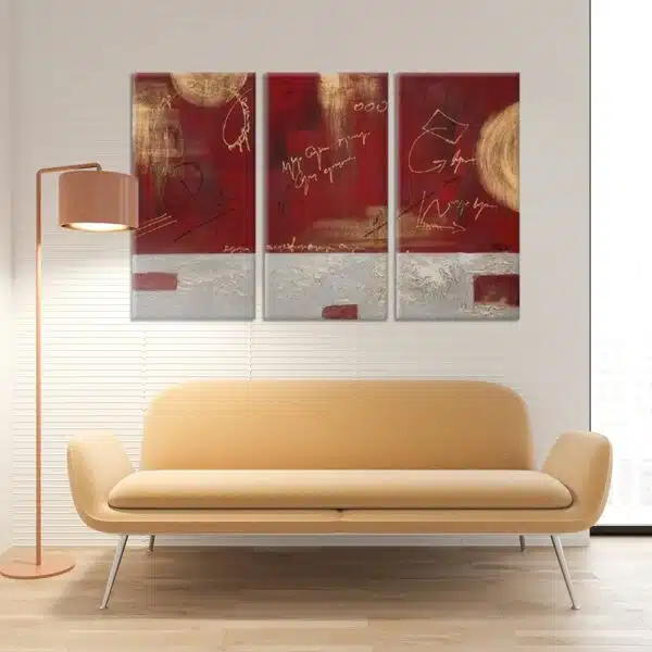 tableau triptyque abstrait rouge et gris, au dessus d'un canapé jaune clair dans un salon moderne.
