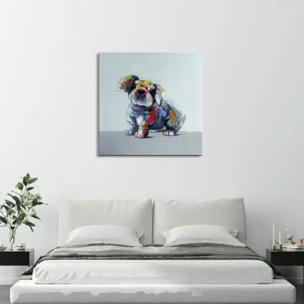Tableau style pop art d'un petit chien aux couleurs gris, bleu, jaune, accroché au-dessus d'un lit à la parure blanche et grise, 2 tables de chevet noirs avec à gauche un vase avec une plante