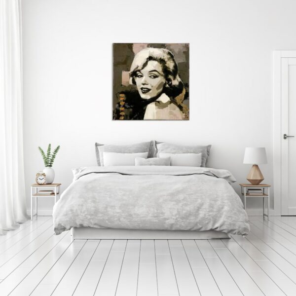 Tableau de Marilyn Monroe dans un style sépia, accrcohé au-dessus d'un lit avec 2 tables de chevets, sur la gauche une plante verte avec un réveil et à droite une lampe