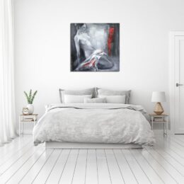 Tableau d'une femme nue à genoux se tenant avec ses mains en arrière avec un drap blanc avec du rouge dessus, accroché au-dessus d'un lit à la parure claire de blanc, gris, avec 2 tables de chevet en métalbmanc avec plateau en bois une plante à gauche et une lampe à droite