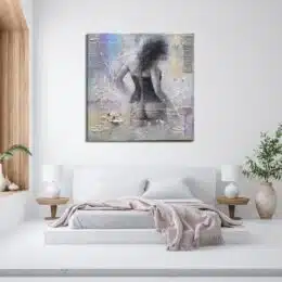 Tableau femme en guêpière de dos nue dans des tons doux de violet, bleu, gris mis au-dessus d'un lit avec un plaid défait sur le bout du lit et 2 chevets avec des lampes blanches, une plante sur la droite et une autre sur le rebord de la fenêtre à gauche