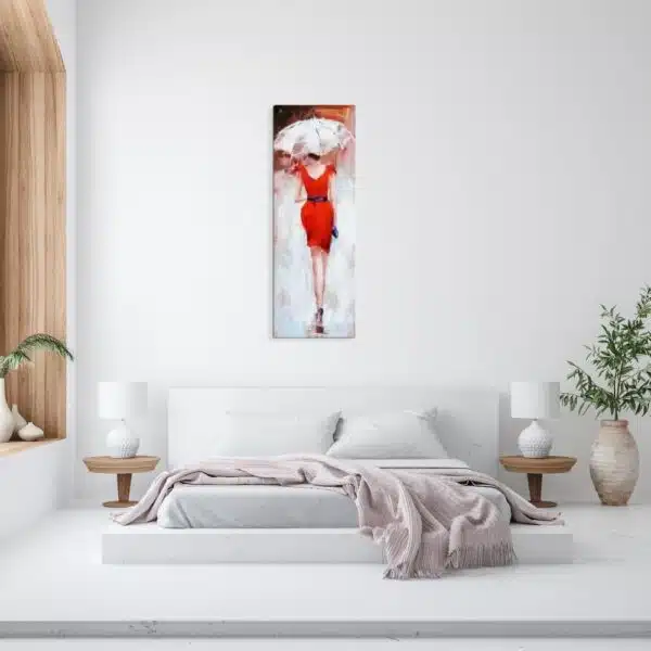 Tableau d'une femme en robe rouge de dos avec un parapluie blanc, accroché au-dessus d'un lit, 2 tables de chevets en bois avec 2 lampes blanches, une plante en terre cuite