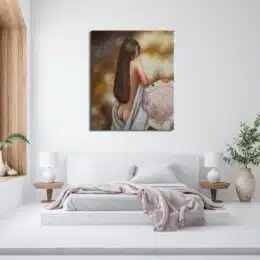 Tableau d'une femme nue aux cheveux longs avec un drap blanc laissant apparaître ses fesses devant un fauteuil accroché au-dessus d'un lit avec un plaid posé au bout du lit et 2 chevets avec des lampes blanche