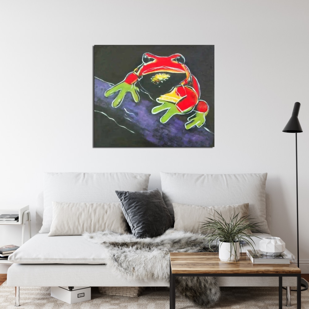 Peinture pop art grenouille Tableau d'une grenouille rouge, jaune et vert sur une branche d'arbre, accrcohé au-dessus d'un canapé gris avec des coussins et une table basse marron carré