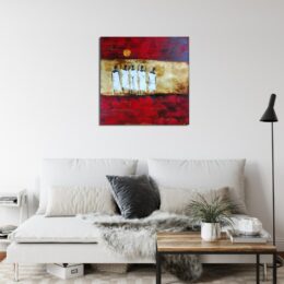 Tableau avec silhouettes africaines dans les tons bordeaux et beige, accroché au-dessus d'un canapé gris avec un coussin noir au milieu et une table en bois marron carré devant