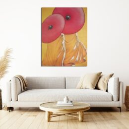 Tableau de 2 moines avec leurs robes orange de dos avec leur ombrelle rouge , au-dessus d'un canapé beige avec des coussins marron et une table basse bois