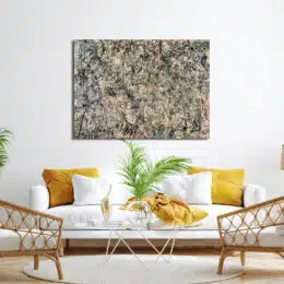 Tableau abstrait, mélange de noir, gris, beige, accroché au-dessus d'un canapé blanc avec coussins jaune moutarde, une table en verre avec une plante verte et 2 fauteuils en rotin