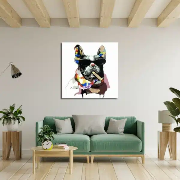 Tableau d'un bouledogue avec des lunettes et un cigare dans un style pop art , accroché au-dessus d'un canapé vert avec 2 tabourets d'appoint en bois avec 2 plantes vertes et une table basse en bois