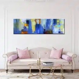 Tableau panoramique bleu peinture abstraite. Bonne qualité, très original, accrochée sur un mur au-dessus d'un canapé rose et une table basse dans une maison