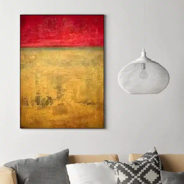 Peinture abstraite orange rouge accrochée sur un mur avec un canapé dans une salon