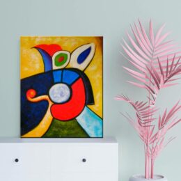 Peinture abstraite moderne jaune rouge bleu. Bonne qualité, original, accrochée sur un mur au dessus d'une table à côté d'une vase dans un salon.