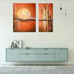Tableau diptique abstrait orange accroché sur un mur avec une table télé dans une maison