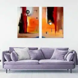 Tableau diptyque abstrait orange accroché sur un mur avec un canapé dans un salon