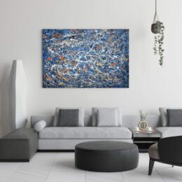 Tableau bleu Jackson Pollock abstraite accroché sur un mur avec un canapé et une table basse dans une maison