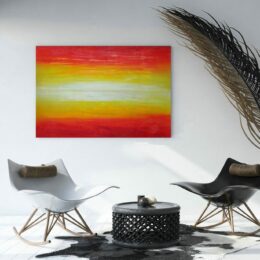 Tableau abstrait jaune et rouge accroché sur un mur avec des chaise et une table basse dans une maison