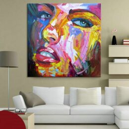 Tableau style pop art d'un visage d'une femme avec des couleurs multicolores, accrcohé au-dessus d'un canapé, avec une veilleuse dans un salon