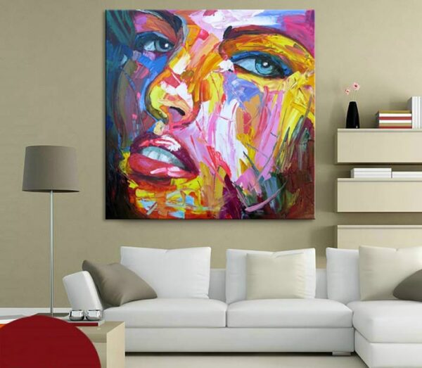Tableau style pop art d'un visage d'une femme avec des couleurs multicolores, accrcohé au-dessus d'un canapé, avec une veilleuse dans un salon