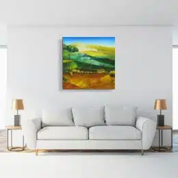 Tableau paysage de provence , accroché sur un mur avec un canapé et une table basse dans une maison