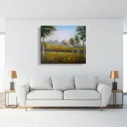 Tableau peinture montagne automne accroché sur un mur avec un canapé dans une maison