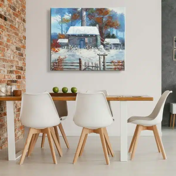 Tableau peinture maison neige accroché sur un mur dans une cuisine avec une table et des chaises