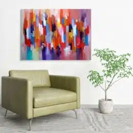 Tableau coloré peinture abstraite, accroché sur un mur avec un canapé dans une maison