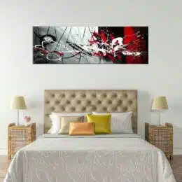 Tableau panoramique grise rouge noire et blanche. Accroché sur un mur avec un lit dans une maison
