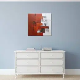 Peinture abstraite grise rouge, a, bonne qualité, très original, accrochée sur un mur bleu au-dessus d'une table blanche dans une maison.