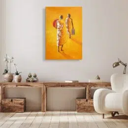 Tableau couleurs chaude orange,jaune, 2 moines marchant de dos, le deuxième avec une ombrelle et le premier un sac dans la main droite, accroché au-dessus d'un meuble bois marron foncé avec un fauteuil blanc devant sur la droite, des caisses de rangement sous le meuble et des plantes posés dessus sur la gauche