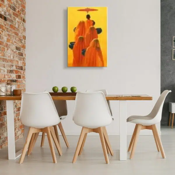 Tableau fond jaune avec groupe de moine avec robe et voile orange, le 1er tiens une ombrelle et les autres des corbeilles noires, accroché dans une cuisine face à une table en bois mis contre un mur en briquette avec les pieds en fer blanc et 5 chaises blanches avec les pieds en bois