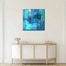 Tableau abstrait bleu azur avec effets vert, bonne qualité, très original, accrochée sur un mur, au-dessus d'une table dans une maison.