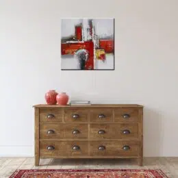 Peinture abstraite gris rouge, accroché sur un mur au-dessus d'une table et une tapis dans une maison