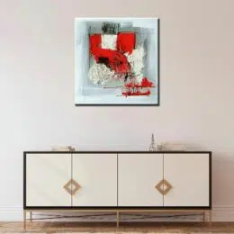 Peinture abstraite rouge et gris, bonne qualité et très original, accrochée sur un mur au-dessus d'une table dans un salon.