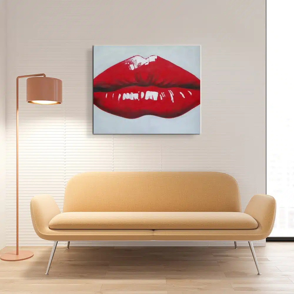Tableau d'une bouche aux lèvres rouge, accrcohé au-dessus d'un canapé jaune et une lampe sur pied à la droite du canapé