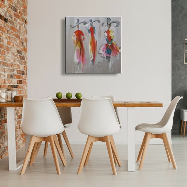 Tableau au fond gris de 3 femmes avec des chapeaux, accrcohé face à une table en bois marron contre un mur en briquettes avec 5 chaises blanches avec les pieds en bois