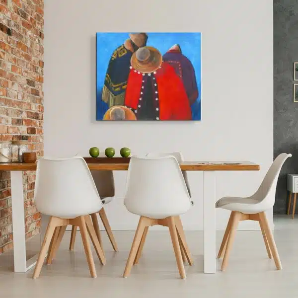 Tableau de 3 personnes avec des chapeaux et tenues péruviennes, accroché en face d'une table en bois contre un mur en briquettes avec 5 chaises blanches, les pieds en bois