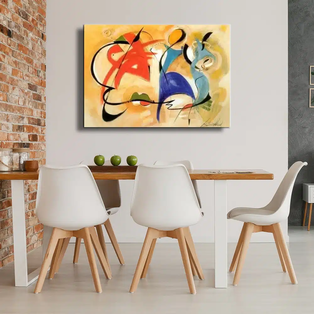 Tableau design couleur principale jaune, différentes formes et silhouette multicolore mis sur un mur blanc d'une cuisine avec une table en bois et 5 chaises blanches avec pieds bois collé à un mur en pierre