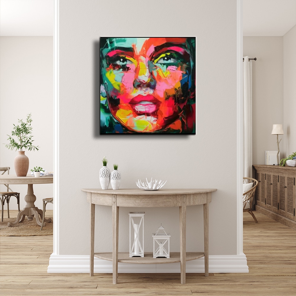 Toile moderne au couteau visage d'une femme Tableau d'un visage femme multicolore style pop, accroché au-dessus d'une console demi-cercle en bois patiné avec 2 vases avec des plantes sur la gauche et en dessous des lampes sémaphore blanc