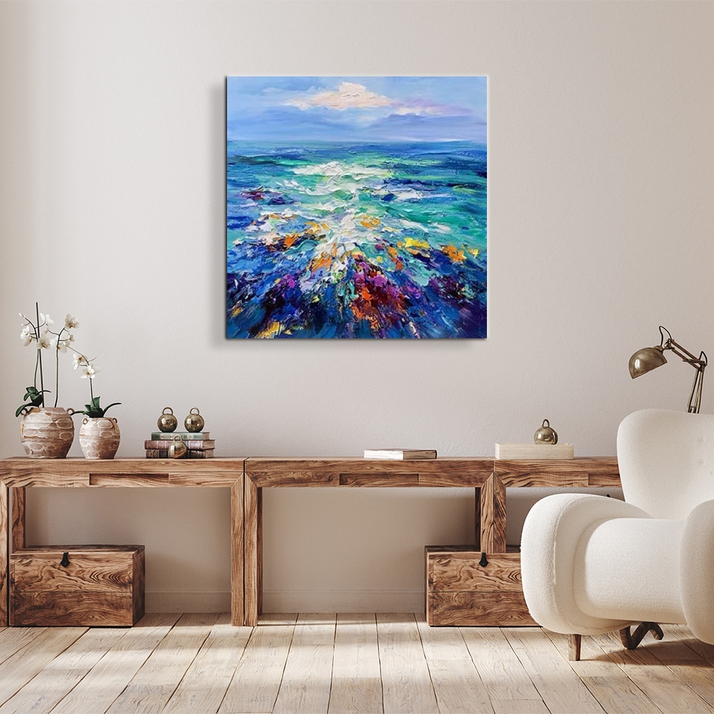 Peinture abstraite mer au couteau Peinture de la mer et le ciel au couteau avec de jolie tonalité de bleu, accroché au-dessus d'une longue table en bois marron, à gauche des vases et en dessous des casiers, à droite un fauteuil blanc