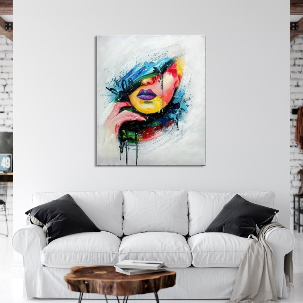 Peinture toile pop art visage femme Tableau d'un visage style pop art, accrcohé au-dessus d'un canapé blanc avec 2 coussins noirs, une table basse en bois