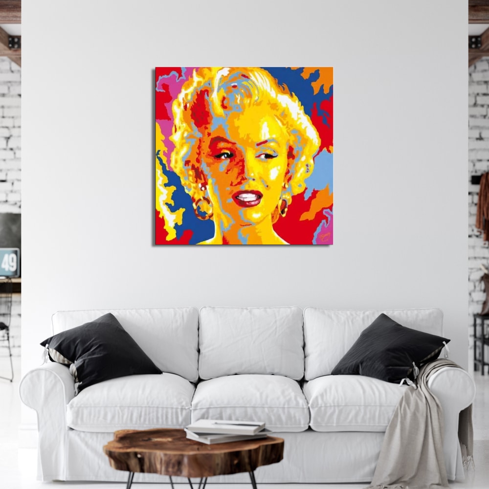 Toile pop art Marylin Monroe Tableau de Marilyn Monroe en style pop art , accroché au-dessus d'un canapé blanc avec 2 coussins noir et une table basse en bois marron
