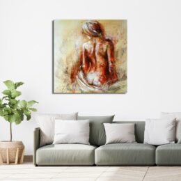 Tableau d'une femme assise de dos avec un drap derrière et le regard sur la gauche, au-dessus d'un canapé vert avec des coussins blanc et beige, une plante dans un pot en terre sur la gauche