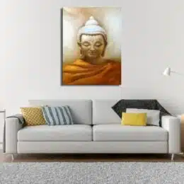 Tableau d'un jbuddha couvert par une robe orange, cheveux blancs en chignon dans un fond beige, accroché au-dessus d'un canapé gris droit avec de gros accoudoirs et des coussins de plusieurs couleurs avec un tapis blanc