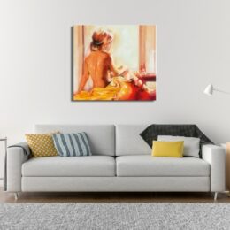 Tableau de dos d'une femme nue face à une fenêtre avec un drap jaune derrière, au-dessus d'un canapé gris avec différents coussins de couleur jaune, blanc, bleu rayé sur un tapis gris chiné