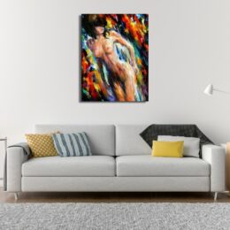 Tableau femme nue dans des couleurs pop, au-dessus d'un canapé gris avec coussins jaune, bleu rayé, gris