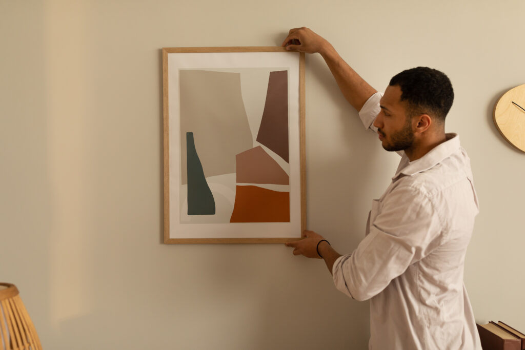 Tableau pas cher Tableau pas cher Blog young black man hanging painting putting picture frame wall indoors modern home decor interior design